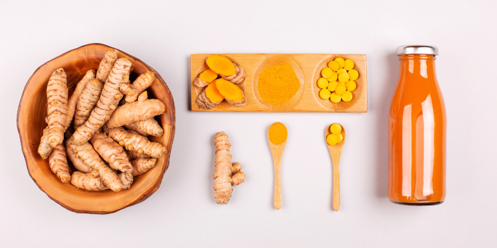 Turmeric root, powder, tablets, and a turmeric drink displayed on a white background