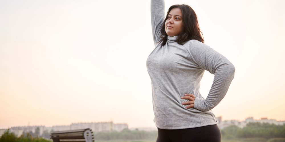 Woman stretching in activewear during a morning workout in the park