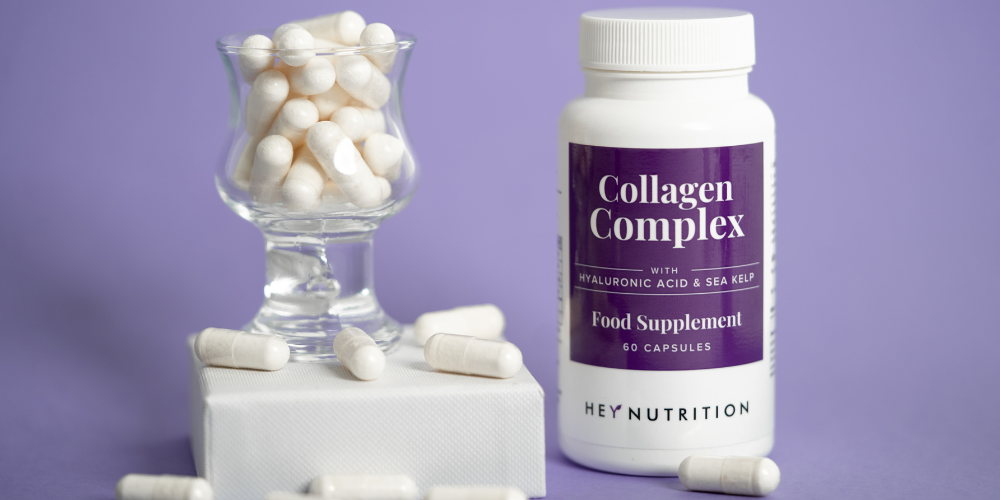 Hey Nutrition Collagen Complex supplement bottle with capsules on a purple background
