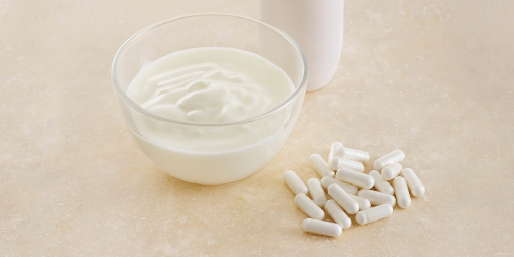 Yogurt and probiotic capsules on a table